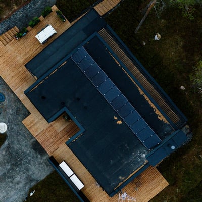 Mustat aurinkopaneelit mustalla katolla sulautuvat osaksi arkkitehtuuria.