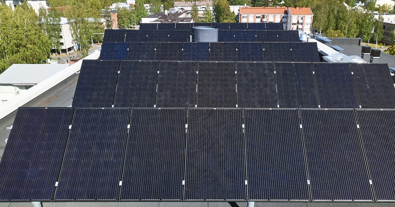 Aurinkopaneelit kerrostalon katolla