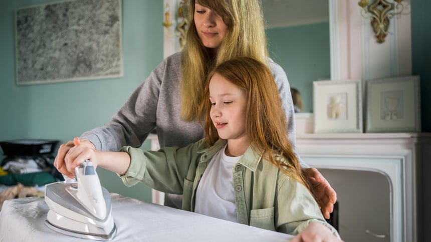 nuori-tyttö-silittää-äidin-avustuksella