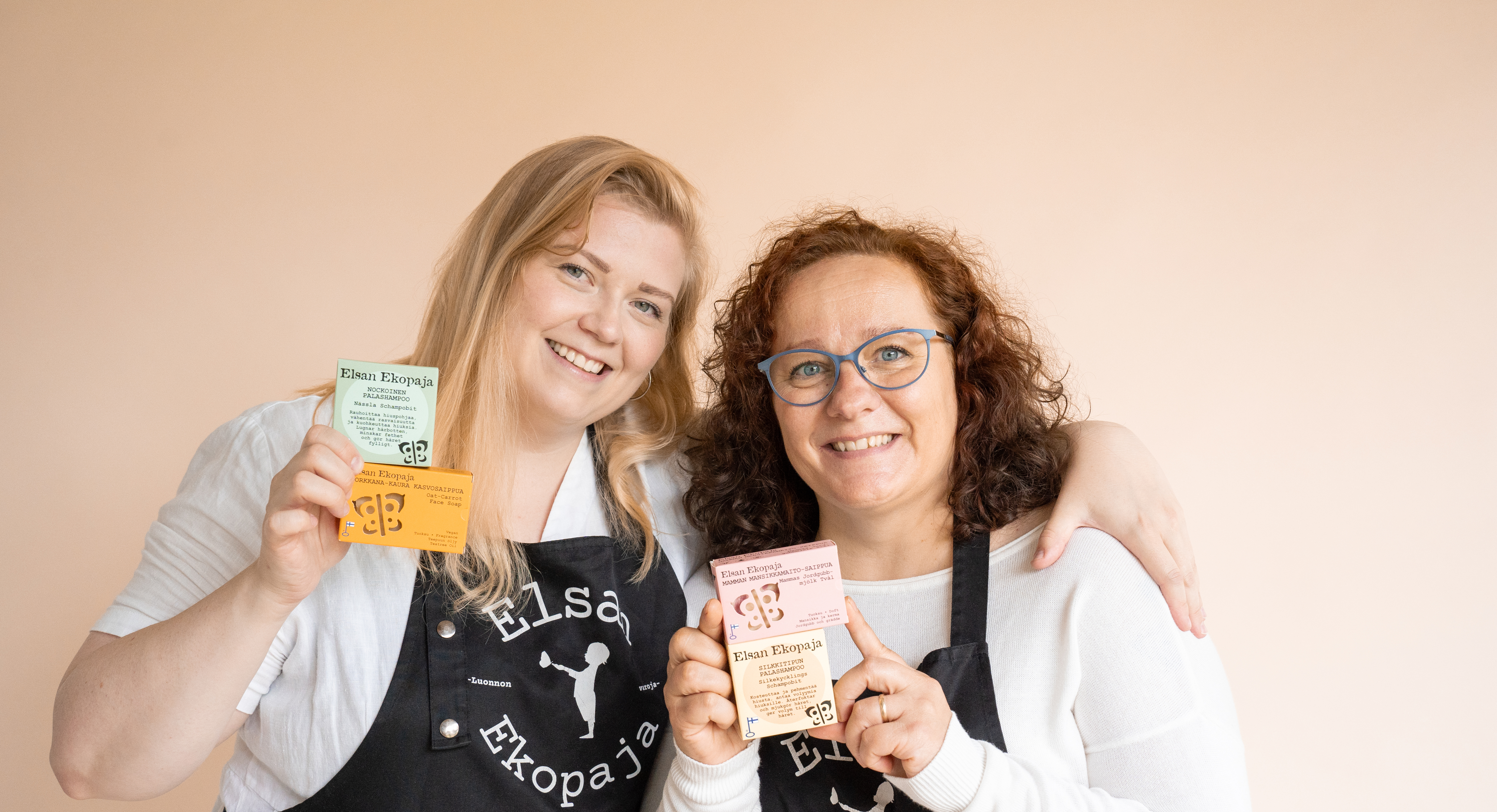 Elsan Ekopajan perustajat Jenni Äijälä ja Mari Tiira hymyilevät ja pitelevät saippuapakkauksia käsissään.
