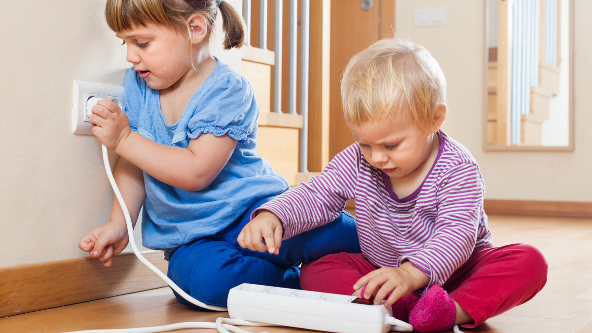 Pienet lapset leikkivät jatkojohdolla