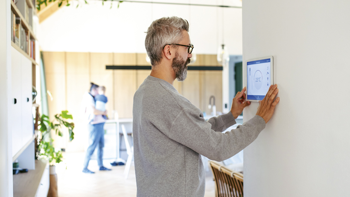 mies säätää kodin lämpötiloja lomamatkan ajaksi