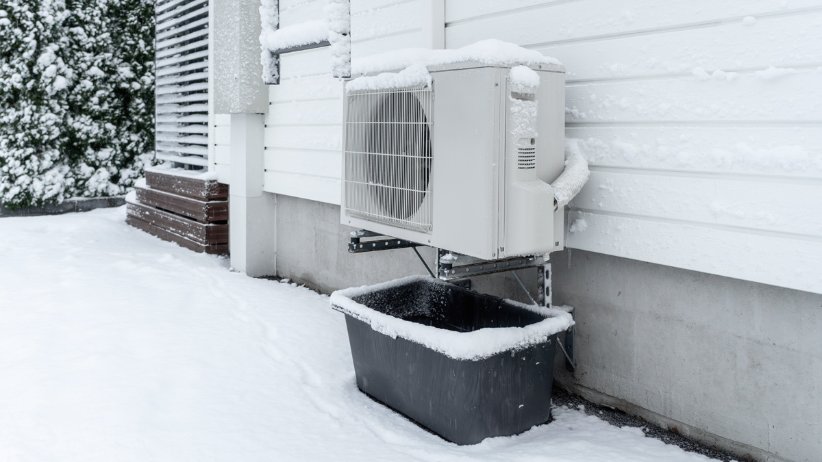 ilmalämpöpumppu pakkasella, talon seinustalla